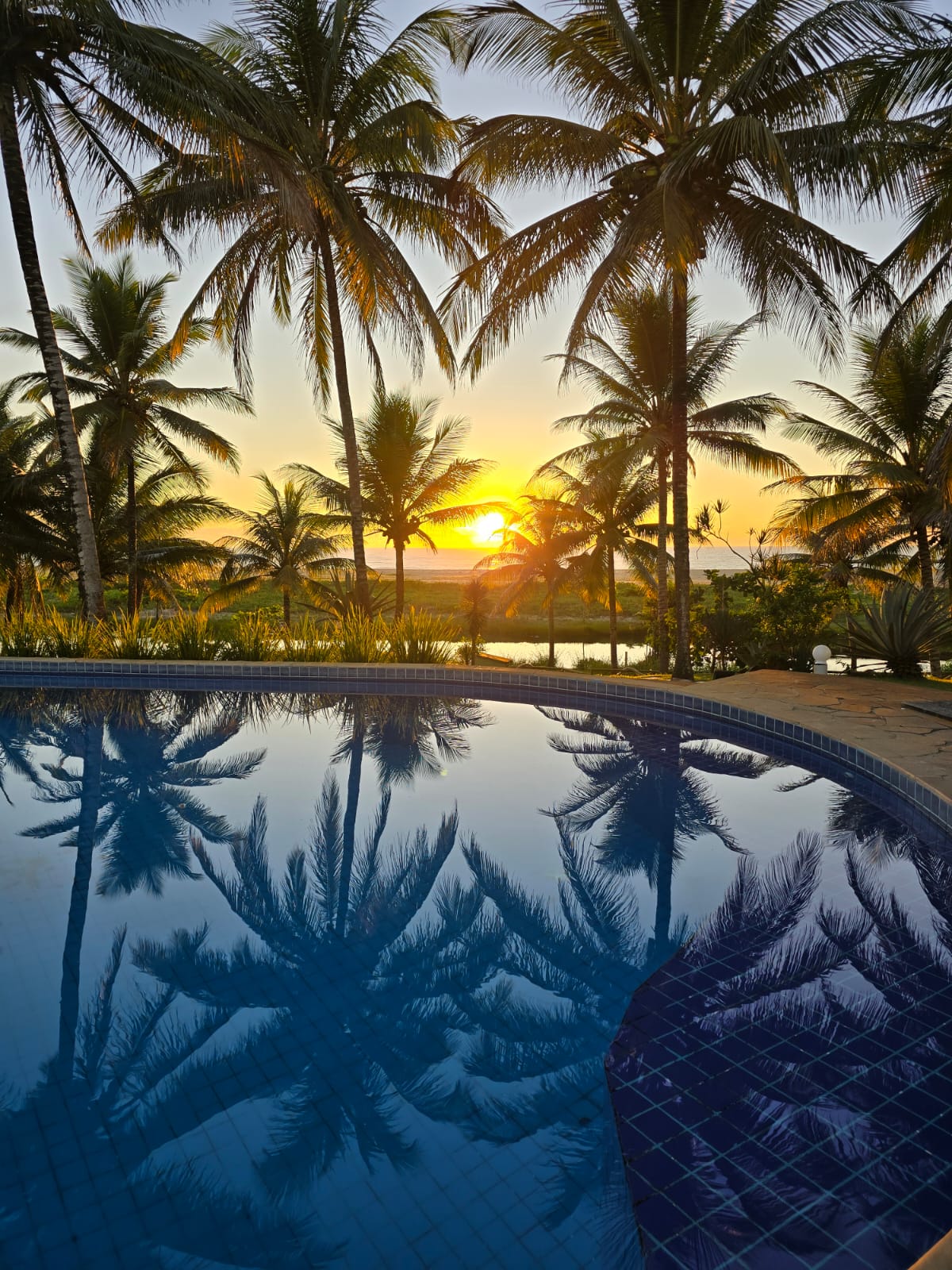Nascer do sol refletido na piscina dos Bangalôs da Professora Eunice